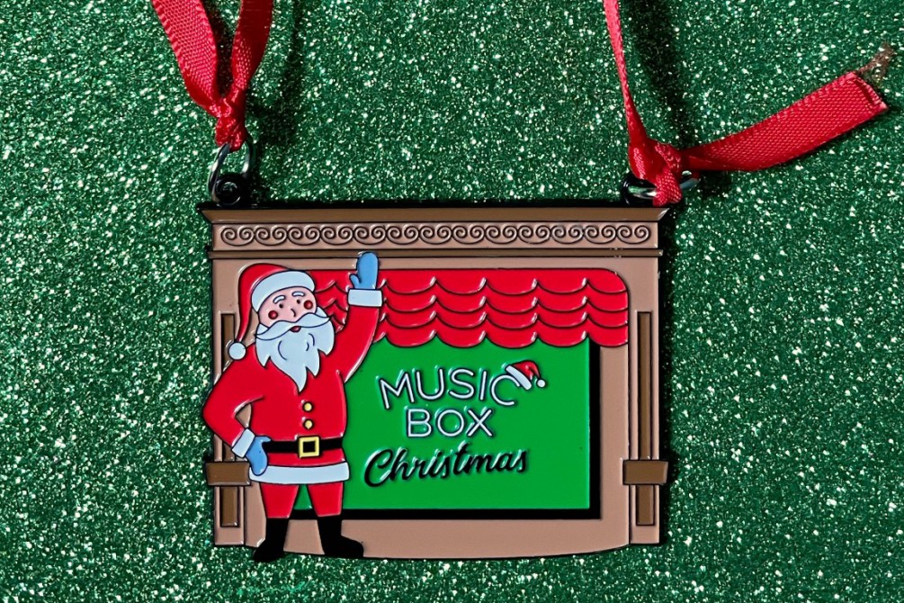 Music Box Christmas ornament featuring Santa Claus waving in front of the red curtain and stage